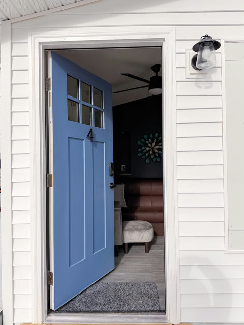 Welcoming blue front door with a stylish, modern interior peek inside