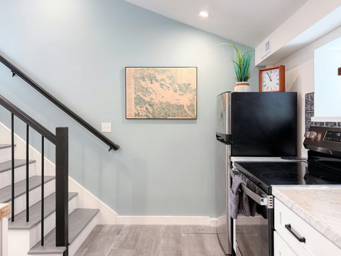 The staircase to your private upstairs bedroom — the framed Lake Winnipesaukee nautical chart sets the tone for your NH Lakes Region escape.