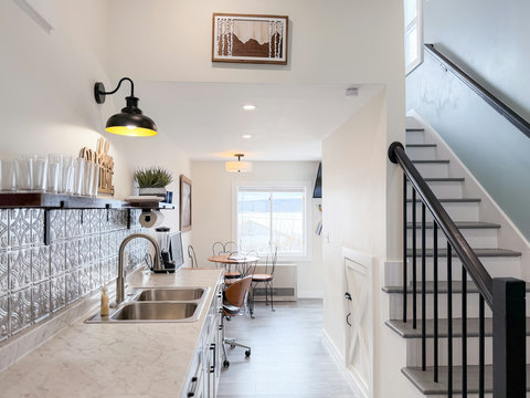 Bright modern kitchen with stylish backsplash and cozy dining nook. Open plan kitchen with views straight through to the dining area and the lake beyond — the layout lives as good as it looks.