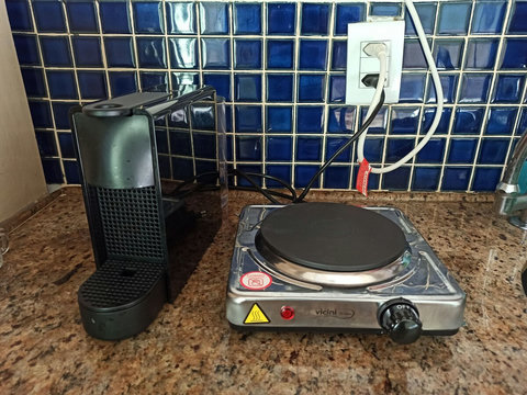 Cafeteira Nespresso e conto Cooktop de uma boca. Há um microondas também.