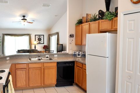 The kitchen overlooks the breakfast bar and lounge/living room beyond.