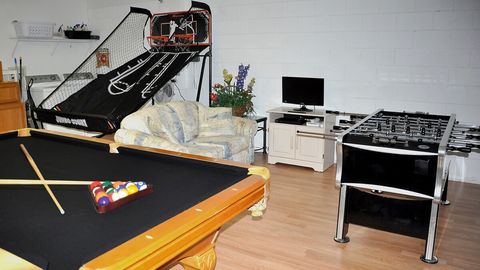 The garage has been converted to a games room, with flooring added and it now features a quality slate pool table, double basketball game and foosball. Note laundry area in the corner.