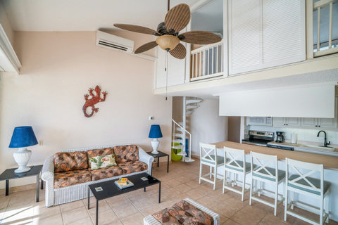 High ceilings and spacious living room with kitchen island bar for guest enjoyment.