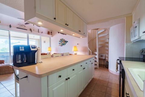 View from fully stocked kitchen looking. Unique spiral staircase in rear leads to second floor bedroom.