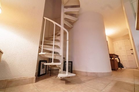 Spiral staircase leading to spacious upstairs loft with ensuite bathroom.