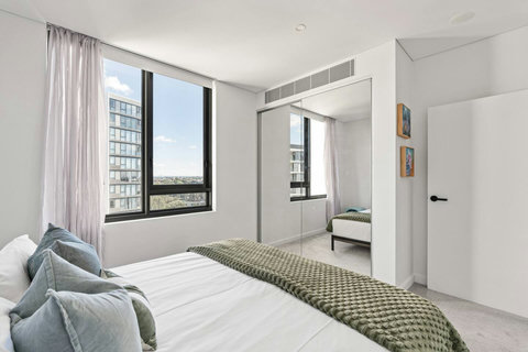 Bright and airy with quality furnishings, this serene bedroom provides a relaxing home away from home.