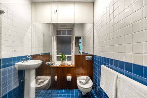 Bathroom | Refresh in the character-filled bathroom with distinctive blue tiling and practical amenities