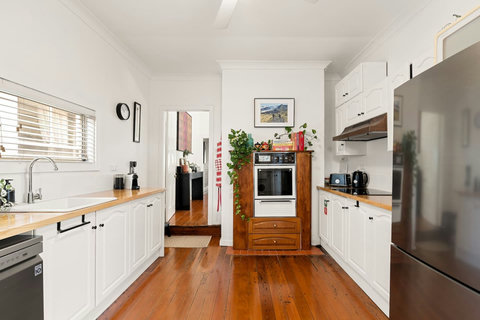 Well-equipped kitchen with dishwasher, oven, cooktop, and coffee machine