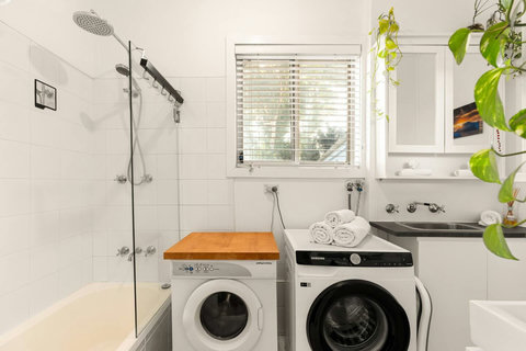 Bathroom with bath, shower, washing machine, and dryer