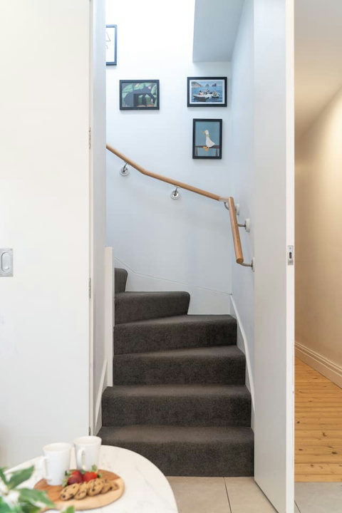 Carpeted stairs connect the home’s bright lower level with the private upstairs bedroom.