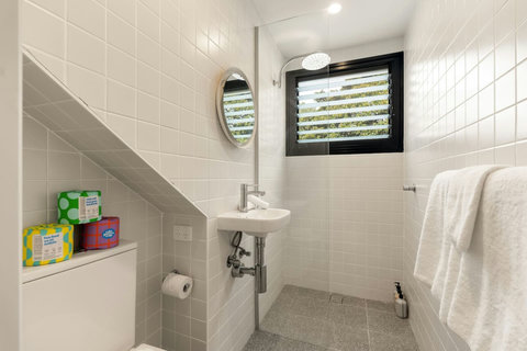 A bright additional bathroom provides a walk-in shower, fresh towels and essential toiletries.