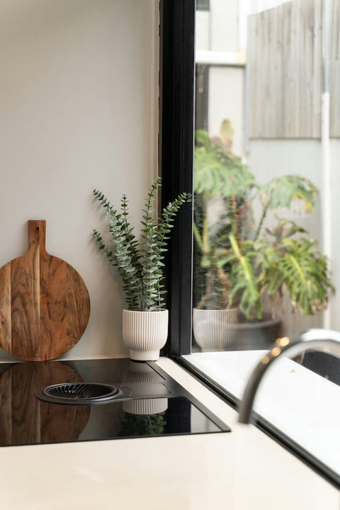 Leafy courtyard views create a refreshing backdrop while preparing meals in the kitchen.
