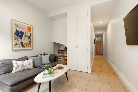 Original timber floors and colourful artwork add warmth and personality to the entrance hall.