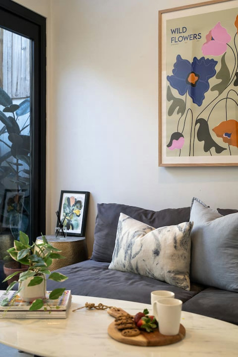 Colourful artwork, soft cushions and leafy courtyard views add personality to the living area.