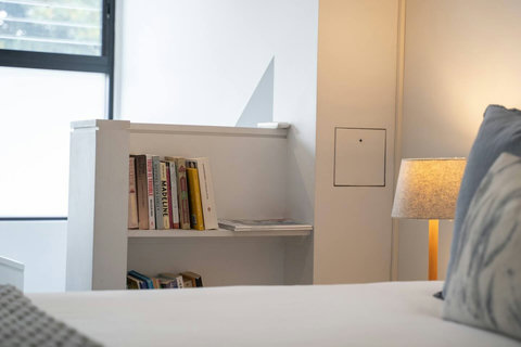A small collection of books is conveniently placed beside the bed for quiet evenings indoors.