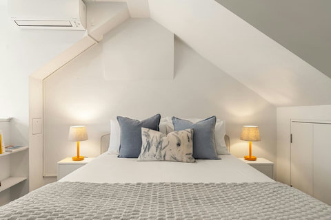 Fresh linen, symmetrical bedside lighting and a peaceful neutral palette make it easy to unwind.