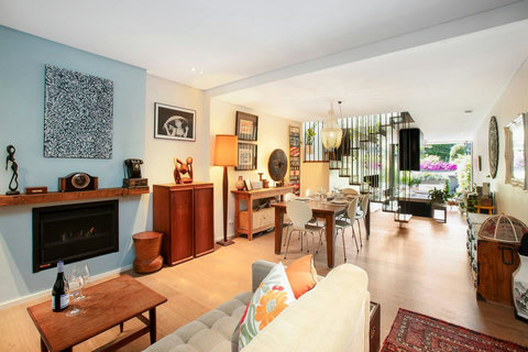 Stylish living space with a fireplace, comfortable seating and views through to the leafy courtyard