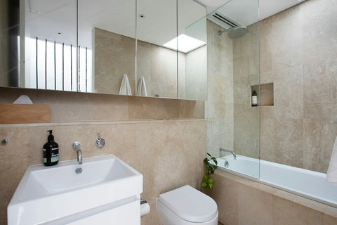 Bright bathroom with a full-size bath, overhead shower and practical vanity storage