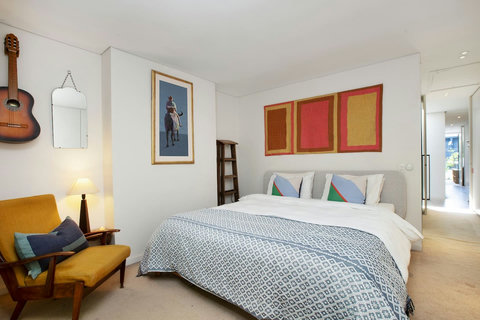 Comfortable bedroom with warm timber accents, artwork and a calm, welcoming feel