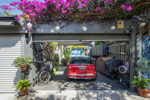 Charming terrace frontage framed by established greenery and colourful bougainvillea