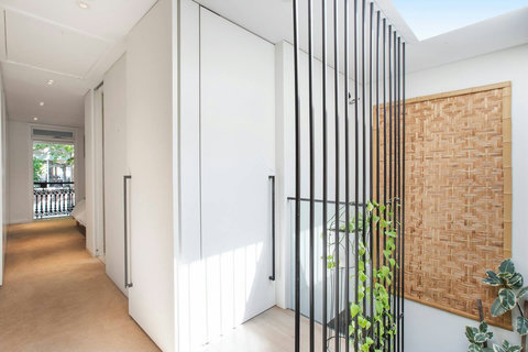 Light-filled hallway with a skylight and striking architectural screening
