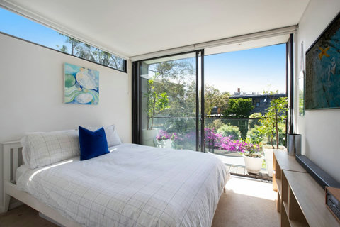 Peaceful bedroom with large glass doors opening directly onto the garden courtyard