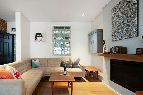 Warm and inviting living room with a generous corner sofa, timber floors and a sleek built-in fireplace