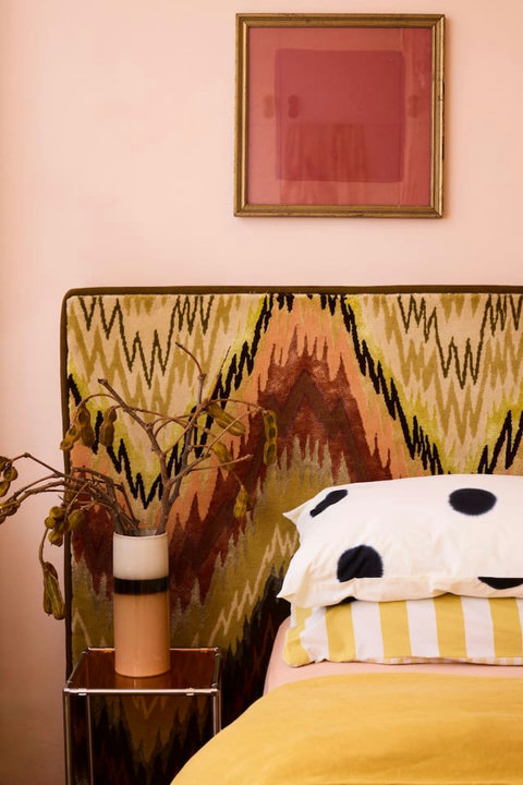 A statement vintage-inspired headboard and warm layered textiles make bedtime feel a little more special