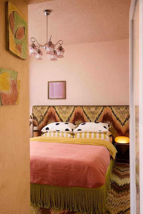 A cosy queen bedroom layered with colour, texture and distinctive designer touches