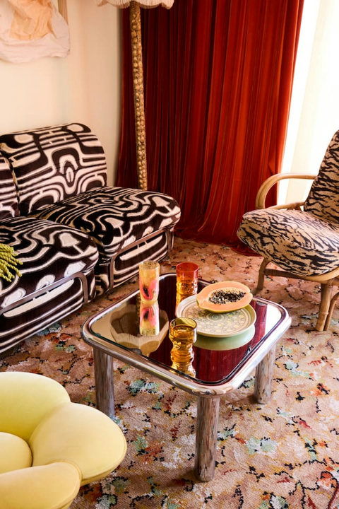 A playful mix of vintage furniture, original art and bold pattern gives the living room its one-of-a-kind personality