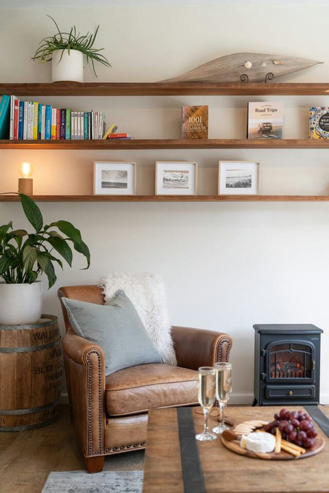 Living Area | Cosy reading nook with warm timber details, comfortable seating and a charming fireplace