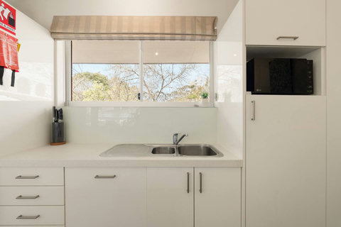 Well-equipped kitchen with generous storage, a double sink and leafy outlook through the window