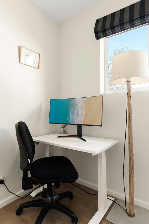 Dedicated workspace with a desk, chair and monitor, ideal for guests working remotely during their stay