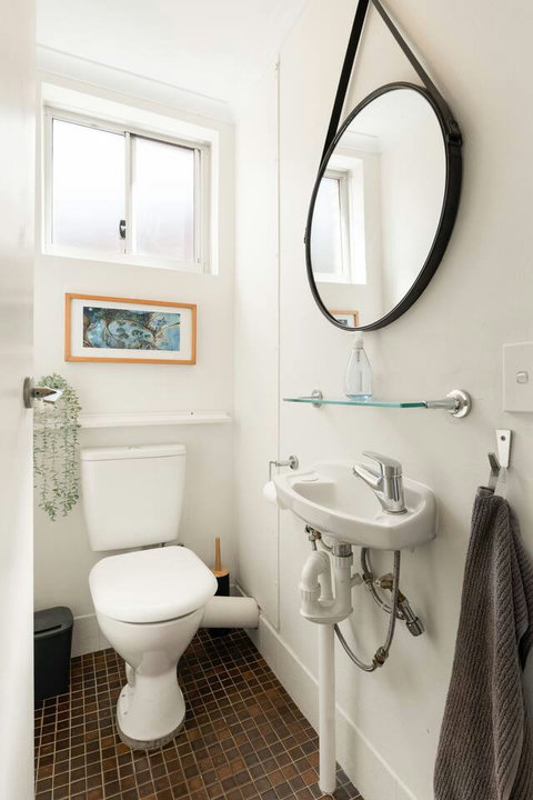 Bright, compact bathroom with a vanity, toilet and plenty of natural light