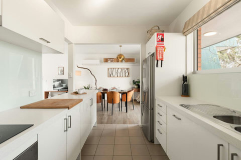 Galley-style kitchen with ample cabinetry, full-size fridge and an easy connection to the dining area