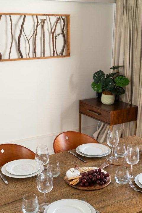 Thoughtful timber furnishings and greenery add warmth and character to the dining area