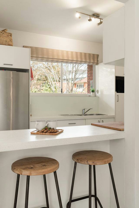 Bright kitchen with generous bench space, stainless steel fridge and a large window bringing in plenty of natural light