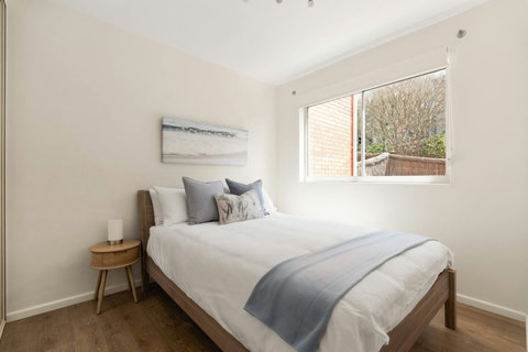 Natural light and relaxed styling make this queen bedroom an inviting place to recharge