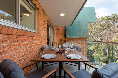 Spacious covered balcony with outdoor dining for four and a leafy residential outlook
