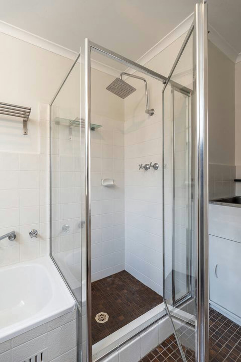 Glass-enclosed shower over the bath, offering a practical setup for everyday use