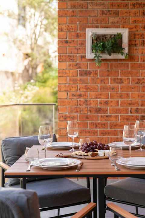 A simple alfresco setting for drinks, snacks or dinner with greenery just beyond the balcony
