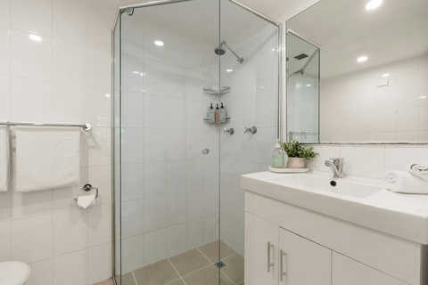 A clean and contemporary bathroom with generous vanity space and a walk-in shower