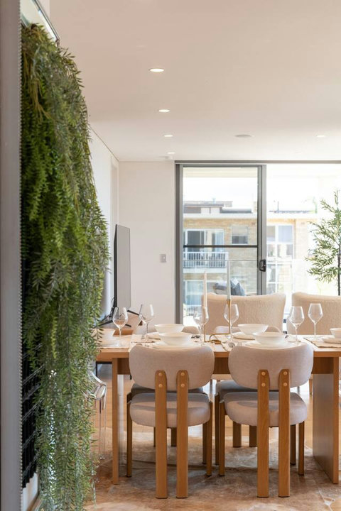 Dining area framed by a striking vertical garden feature, with terrace access and natural light nearby
