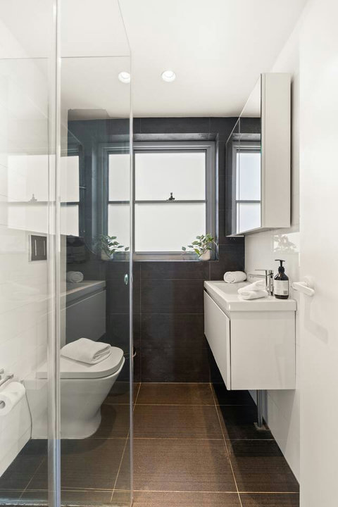 Contemporary bathroom with a walk-in shower, compact vanity and clean monochrome finishes