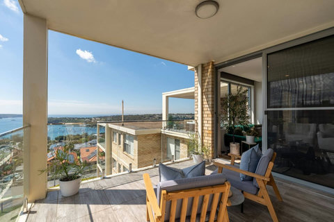Private covered terrace with relaxed seating and wide views across Balmoral Bay