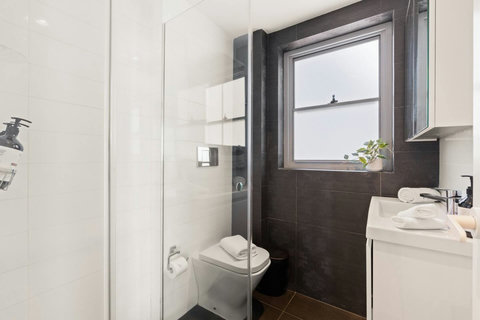 Contemporary bathroom with a walk-in shower, compact vanity and crisp neutral finishes