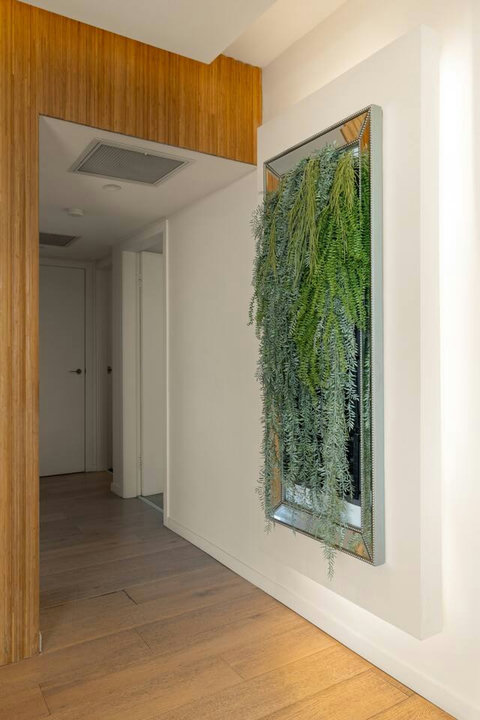 Hallway accented by a vertical garden feature, adding greenery and texture to the interior