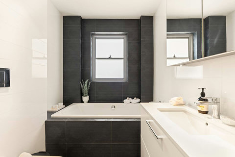 Main bathroom with a full-size bathtub, generous vanity and clean contemporary finishes