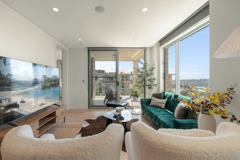 Bright living room with harbour views, large windows and a comfortable mix of lounge seating