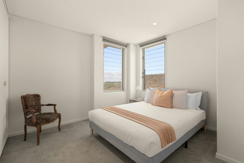 Comfortable queen bedroom with a simple, airy layout and soft neutral styling